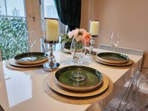 een tafel met twee groene borden en glazen erop bij Home from Home Slough in Slough