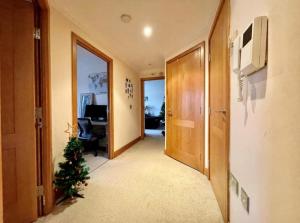 a hallway with a christmas tree in a room at Cosy 2 bedroom appartment with gated parking by River Thames in Kingston upon Thames