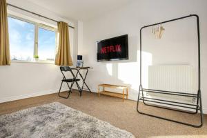 un soggiorno con specchio e tavolo di Aylesbury House with Free Parking, Super-Fast Wifi and Smart TV with Netflix by Yoko Property ad Aylesbury