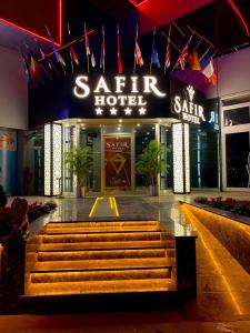 Safir Hotels Silivri في سيليفري: فندق ساتر في الليل مع مقعد في الأمام