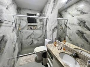a bathroom with a shower and a sink and a toilet at Casa temporada familiar in Cabo Frio +33 photos