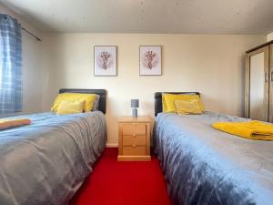 duas camas sentadas uma ao lado da outra num quarto em Comfy Letchworth Apartment by Leecroft Stays em Letchworth