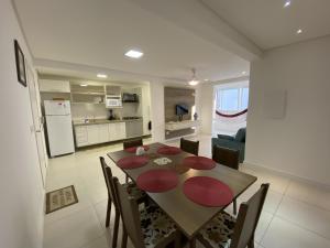 a kitchen and dining room with a table and chairs at Apartamento em Torres 2 quartos centro 1 quadra do mar - 906 in Torres