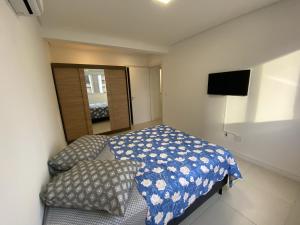 Dormitorio pequeño con cama y espejo en Apartamento em Torres-906 - Uma quadra do mar, en Torres