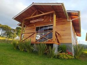 a small wooden house with a large window at Pousada Flor do Campestre in Urubici
