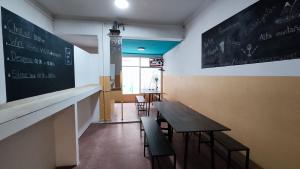 een klaslokaal met een tafel en stoelen en een schoolbord bij VI&VI HOSTEL MENDOZA in Mendoza