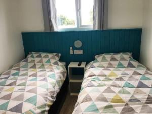 two beds sitting next to each other in a bedroom at Woolacombe Breaks - ‘Sea La Vie’ in Woolacombe