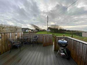 una terrazza con tavolo, sedie e griglia di Woolacombe Breaks - ‘Sea La Vie’ a Woolacombe