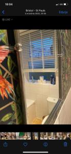 a bathroom with a toilet and a window and a mirror at Exclusive apartment in Bristol in Bristol