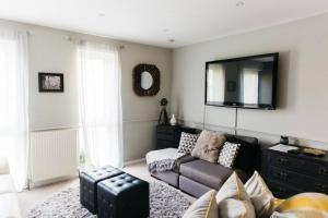 a living room with a couch and a flat screen tv at Holloway House in Bath