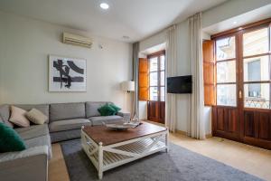 a living room with a couch and a coffee table at HomeySeville-Amazing Views Cathedral Tomas de Ibarra - 8 pax, Parking Optional in Seville