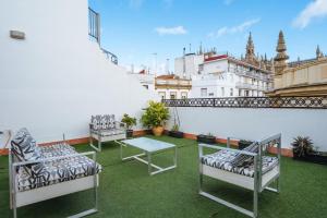 a balcony with two chairs and a table on a roof at Amazing Views Cathedral Tomas de Ibarra - 8 pax, Parking Optional in Seville