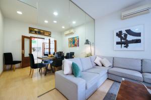 a living room with a couch and a dining room at HomeySeville-Amazing Views Cathedral Tomas de Ibarra - 8 pax, Parking Optional in Seville