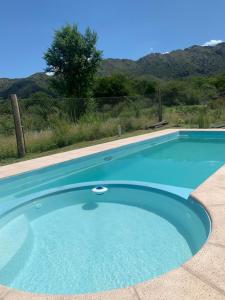una gran piscina azul con montañas en el fondo en Las Moras en San Luis