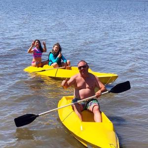 un grupo de personas montando en kayaks amarillos en el agua en Venha curtir suas férias, com privacidade em Laguna-SC, en Laguna