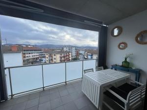a balcony with a table and a view of a city at Kobentu Berri by Smiling Rentals in Hondarribia