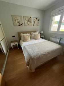 a bedroom with a large bed and two windows at Kobentu Berri by Smiling Rentals in Hondarribia