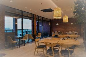 ein Restaurant mit Holztischen und -stühlen und großen Fenstern in der Unterkunft West Prime Hotel in Calbayog