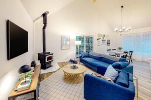 a living room with a blue couch and a fireplace at Treehouse by the Sea in Cape Meares