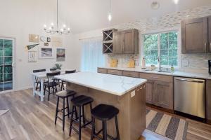a kitchen with a large island with bar stools at Treehouse by the Sea in Cape Meares