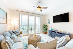 een woonkamer met een bank en een flatscreen-tv bij Majestic Sun B1010 in Destin