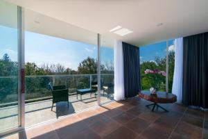 una sala de estar con grandes ventanas de cristal y una mesa. en Hotel Balcón del Parque en Xalapa