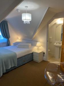 a bedroom with a bed and a sink and a chandelier at A & B Guest House Cambridge in Cambridge +31 photos