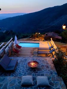 a fire pit on a patio next to a pool at Casa do Ti Tóte in Talasnal