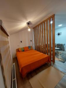 - une chambre avec un lit orange dans l'établissement Dolly Zlatibor, à Zlatibor
