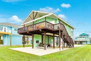 a house with a deck on a lawn at Terramar Time in Galveston