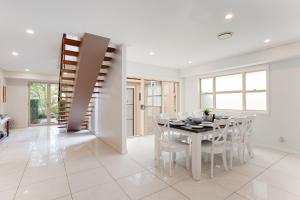 a white dining room with a table and chairs at 25 Christmas Bush Avenue aircon pet friendly small boat parking and WI FI in Nelson Bay