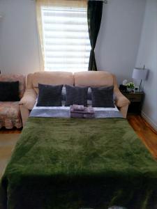 um quarto com uma cama grande e um sofá em Downtown apartment next to highway netflix+wifi em Edmundston