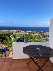 a table on a balcony with a view of the ocean at Apartamentos y Habitaciones Villa Marina in La Caleta