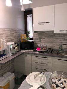 une cuisine avec des placards blancs et un comptoir dans l'établissement B&B Vittorio Emanuele, à Cirò Marina