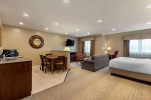 um quarto de hotel com uma cama e uma sala de jantar em Best Western PLUS Vineyard Inn and Suites em Penn Yan