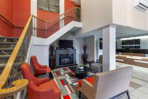 a living room with orange chairs and a fireplace at Best Western Plus Burlington Inn & Suites in Burlington