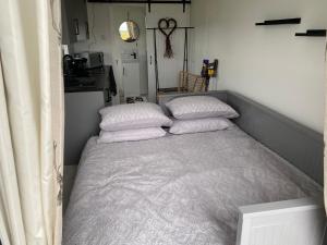 un letto in una piccola stanza con due cuscini sopra di Farr North Lodge 1 a Wick