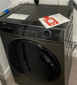 a black washing machine with a box on top of it at Escape Homes in Barking