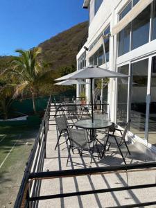a patio with a table and chairs and an umbrella at El Cielo en la laguna. in Santa María del Oro