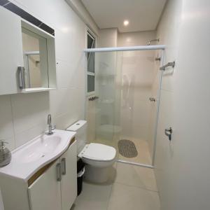 ein Bad mit einem WC, einem Waschbecken und einer Dusche in der Unterkunft Apartamento em Torres-906 - Uma quadra do mar in Torres