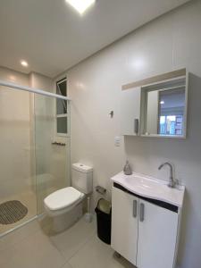 y baño con aseo, lavabo y ducha. en Apartamento em Torres-906 - Uma quadra do mar, en Torres