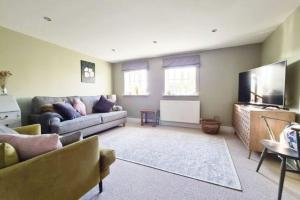 a living room with a couch and a flat screen tv at Brisley North Norfolk cosy cottage garden pub and walks in Beetley