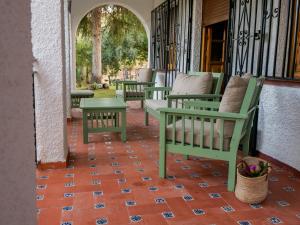 una fila de sillas y mesas en un porche en Villa Ricardo, en Fornes