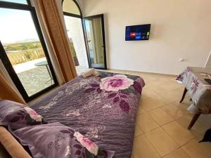 uma sala de estar com uma cama com um cobertor de flores em Apartments Plaza em Ulcinj