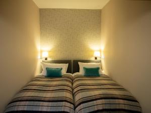 a bedroom with a bed with two green pillows at The Beeches - Chatsworth Apartment No 5 - Sleeps 4 in Baslow