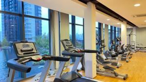 a gym with a row of treadmills and ellipticals at Hannah's Cottage at KL East The Ridge in Kuala Lumpur