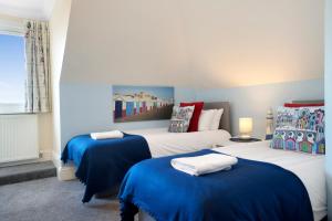 2 letti in una camera con blu e bianco di Brunswick Fab Pad - By My Getaways a Brighton & Hove