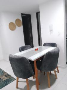 a dining room with a white table and four chairs at Apartamento en el centro de la ciudad bonita a muy buen precio in Bucaramanga