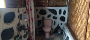 a bathroom with a pink toilet in a room at Mysha Guest House-Lombok in Tetebatu