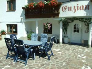 a blue table and chairs in front of a building at Haus Enzian in Sankt Leonhard im Pitztal